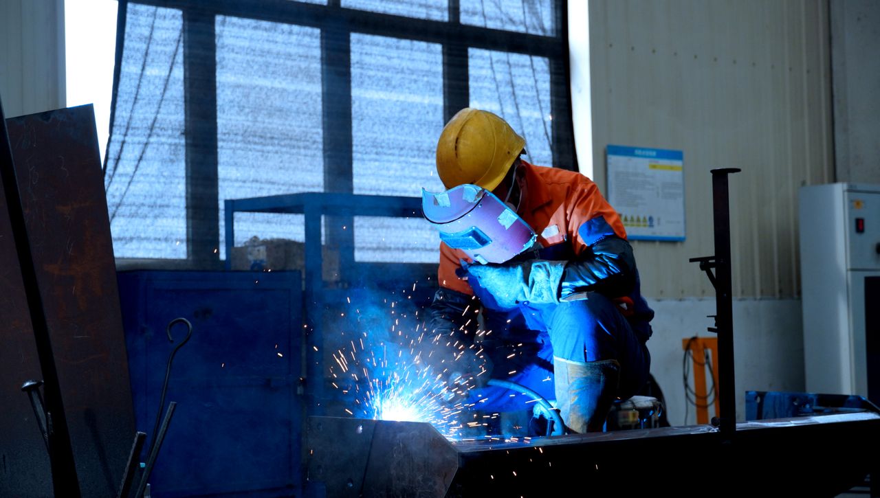 Mastering the First Impression: Your intriguing post title goes here A welder in protective gear works in a factory, creating bright blue sparks.