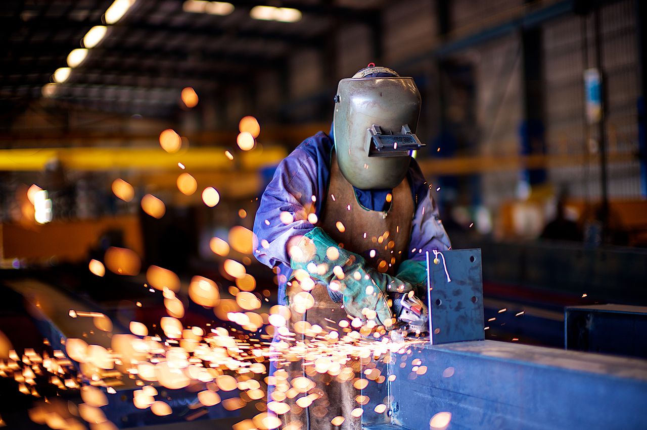Crafting Captivating Headlines: Your awesome post title goes here An industrial worker in a workshop welding metal with protective gear, creating vibrant sparks.